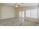 Living room features wood-look tile floors, ceiling fan, and sliding glass door access to the backyard at 22139 N Van Loo Dr, Maricopa, AZ 85138