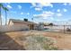 View of the backyard with tan-colored grass, block wall, swimming pool and view of rear exterior at 2215 N 58Th Dr, Phoenix, AZ 85035