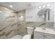 Bathroom featuring a shower with decorative tile, matching countertops and round mirror at 2215 N 58Th Dr, Phoenix, AZ 85035