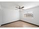 Bright bedroom featuring laminate floors, white walls, ceiling fan, and window at 2215 N 58Th Dr, Phoenix, AZ 85035