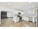 Well-lit kitchen featuring stainless steel appliances, white cabinetry, and access to an adjacent living area at 2215 N 58Th Dr, Phoenix, AZ 85035