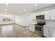 Open kitchen area with stainless steel appliances, white cabinets, and seamless flow into the living space at 2215 N 58Th Dr, Phoenix, AZ 85035