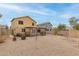 Large backyard featuring a covered patio, windmill decoration and desert landscaping at 2558 W Jasper Ave, Apache Junction, AZ 85120