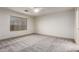 Bedroom with large window, ceiling fan, and neutral carpeting at 2558 W Jasper Ave, Apache Junction, AZ 85120