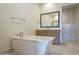 Bright bathroom featuring a freestanding tub, vanity with framed mirror, and tiled walk-in shower at 2779 E Derringer Way, Gilbert, AZ 85295