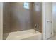 Bathroom shower featuring a white tub and gray horizontally stacked tiles at 2779 E Derringer Way, Gilbert, AZ 85295