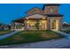 Striking exterior view of the clubhouse featuring a stone facade, covered patio, and lush green lawn at 2779 E Derringer Way, Gilbert, AZ 85295