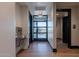 Bright hallway with exit door, water fountain, and black framed entry to restrooms at 2779 E Derringer Way, Gilbert, AZ 85295