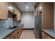 Kitchenette with modern appliances, gray counters, and wood cabinets at 2779 E Derringer Way, Gilbert, AZ 85295