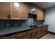 Kitchenette with wooden cabinets, gray countertop, stainless steel refrigerator, and mosaic tile backsplash at 2779 E Derringer Way, Gilbert, AZ 85295