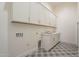 Bright laundry room with decorative tile floors, white cabinets, and a utility sink at 2779 E Derringer Way, Gilbert, AZ 85295