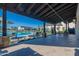 Inviting community pool view from covered patio with stone columns and travertine tile floors at 2779 E Derringer Way, Gilbert, AZ 85295