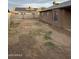 Large, enclosed backyard featuring dirt and partial grass, ready for customization and landscaping opportunities at 304 E Madison St, Avondale, AZ 85323