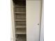 Linen closet with a partially open sliding door and multiple shelves at 304 E Madison St, Avondale, AZ 85323