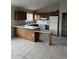 Kitchen featuring tile flooring, oak cabinets, white appliances, and a breakfast bar at 304 E Madison St, Avondale, AZ 85323