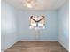 This bedroom features wood-look floors, light blue walls, and a window with curtains and window trim at 3330 E Main St # 250, Mesa, AZ 85213