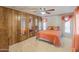 Bright bedroom with ceiling fan, wood paneling, mirrored closet doors, and patterned wallpaper at 3330 E Main St # 250, Mesa, AZ 85213