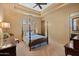 Serene bedroom showcasing dark wood furniture, a four-poster bed, tray ceiling, and relaxing ambiance at 3756 N Rock Wren Ct, Buckeye, AZ 85396