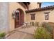 Charming outdoor courtyard with brick patio, seating, and red arched door and window frames at 3756 N Rock Wren Ct, Buckeye, AZ 85396