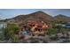 Exterior view of this charming home featuring a sparkling pool and a backdrop of mountains and desert landscape at 3756 N Rock Wren Ct, Buckeye, AZ 85396