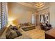 Cozy living room offers a comfortable sofa, leather chair, and a decorative ceiling, perfect for relaxation at 3756 N Rock Wren Ct, Buckeye, AZ 85396