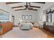 Main bedroom with ceiling beams, tiled floors, large windows and a seating area at 3756 N Rock Wren Ct, Buckeye, AZ 85396