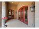 Inviting covered patio entrance features stylish lighting fixtures and double red-framed doors at 3756 N Rock Wren Ct, Buckeye, AZ 85396