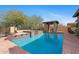 Resort-style pool features a covered lounge area and a seamless connection to the serene landscape at 3756 N Rock Wren Ct, Buckeye, AZ 85396