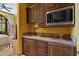 A convenient wet bar featuring beautiful countertops, custom cabinetry and a microwave enhances this space at 3756 N Rock Wren Ct, Buckeye, AZ 85396