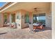 An outdoor covered patio features tile flooring, a ceiling fan, desert views, and outdoor seating at 41225 N River Bend Rd, Phoenix, AZ 85086