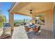 An outdoor covered patio space with tile flooring, a ceiling fan, desert views, and outdoor seating at 41225 N River Bend Rd, Phoenix, AZ 85086