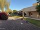 Manicured backyard featuring lush green lawn, desert landscaping, and private patio at 4336 E Encanto St, Mesa, AZ 85205