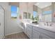 Bright bathroom with double sinks, a spacious mirror, stylish decor, and a view of the outdoors at 44323 N 43Rd Dr, Phoenix, AZ 85087