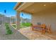 Outdoor patio area with a pergola, artificial grass, a table and seating, and exterior lighting at 44323 N 43Rd Dr, Phoenix, AZ 85087