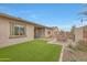 Spacious backyard featuring a covered patio, artificial grass, and modern outdoor seating at 44409 N 43Rd Dr, Phoenix, AZ 85087