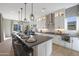 Modern kitchen with a long center island with pendant lighting and seating at 44409 N 43Rd Dr, Phoenix, AZ 85087