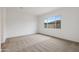 Bright bedroom showcasing neutral carpet and a window view of the backyard at 44717 N 44Th Dr, Phoenix, AZ 85087