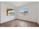 A bright bedroom with wood-look tile floors and two windows offering natural light at 44717 N 44Th Dr, Phoenix, AZ 85087