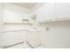 Well-organized laundry room with white cabinets, sink, and tiled floor at 5682 N Scottsdale Rd, Paradise Valley, AZ 85253