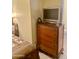 This bedroom features vintage furniture, including an old wooden dresser and television at 6125 E Indian School Rd # 216, Scottsdale, AZ 85251