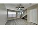 A living room with gray vinyl flooring, a staircase, and a large window with blinds at 625 S Westwood St # 108, Mesa, AZ 85210