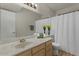 Neutral bathroom featuring a marble counter, wooden cabinets, and a white shower curtain at 6915 E Gary Cir, Mesa, AZ 85207