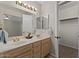 Bathroom featuring double sinks, vanity lighting, and an adjacent walk-in closet at 6915 E Gary Cir, Mesa, AZ 85207