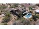 Aerial backyard view of a home featuring a pool, covered patio, desert landscape, grassy area, and parking at 7100 E Montgomery Rd, Scottsdale, AZ 85266