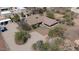 Expansive desert property featuring a tan home with an attached carport and a sparkling blue pool at 7100 E Montgomery Rd, Scottsdale, AZ 85266