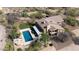 Desert home featuring a large pool, rock waterfall feature, second story balcony, and lush desert landscaping at 7100 E Montgomery Rd, Scottsdale, AZ 85266