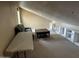 Carpeted bonus room with vaulted ceilings, sofa, built-in shelves and natural light is perfect flex space at 7100 E Montgomery Rd, Scottsdale, AZ 85266