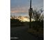 Gravel driveway leads to a property featuring a large Saguaro cactus set against a sunset sky at 7100 E Montgomery Rd, Scottsdale, AZ 85266