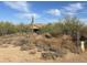 Desert property with a saguaro cactus and a home visible in the background beyond the fence at 7100 E Montgomery Rd, Scottsdale, AZ 85266