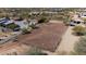 Aerial view of a horse arena with fencing, desert landscape, and nearby houses in a desert community at 7100 E Montgomery Rd, Scottsdale, AZ 85266